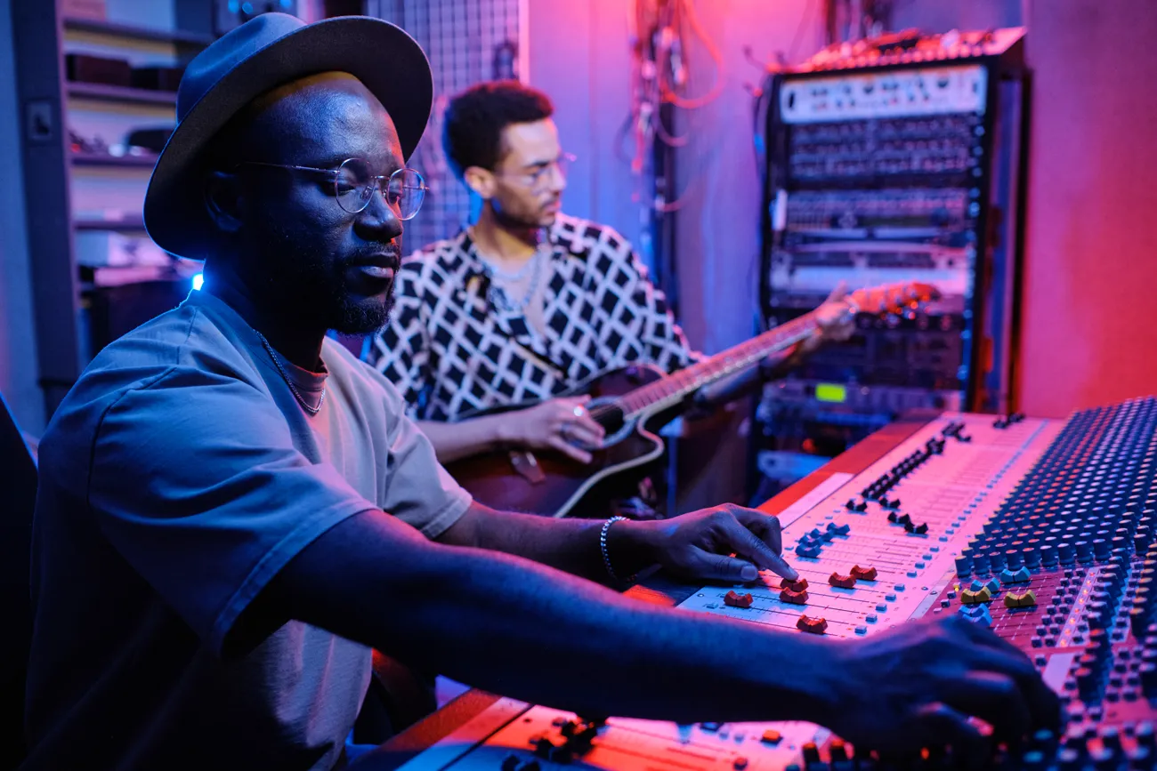 Two musicians working at a mixing desk in a studio